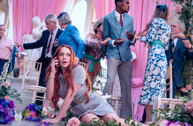 Maddie (Lindsay Lohan) makes a phone call from the floor of a wedding as guests fight each other behind her.