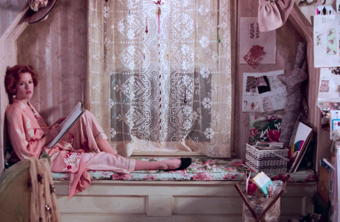 Andie sits in the window seat, sketchbook in her lap